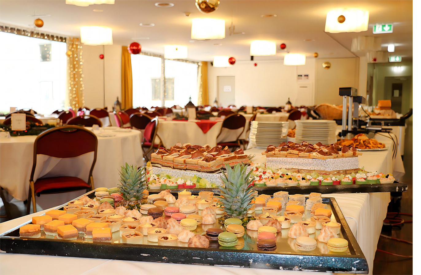 Buffet de fête dressé en salle à manger : canapés, mignardises et macarons.